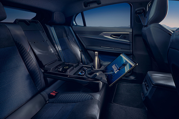 Renault Rafalen takaistuimet ja ingenius-kyynärnoja alas laskettuna. Kyynärnojassa juomapullo, tabletti sekä älypuhelin latauksessa.