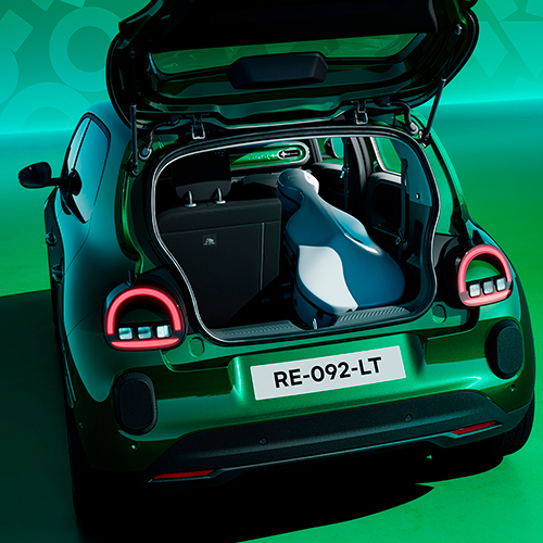 Absolu vihreä Renault Twingo E-Tech electric tavaratilan luukku avoimena, tavaratilassa soitinkotelo.