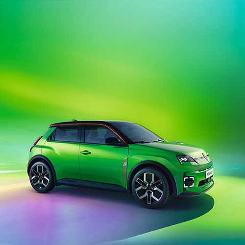 Renault 5 E-Tech electric pop! vihreän värissä sivusta kuvattuna vihreää taustaa vasten.