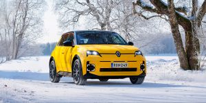 Keltainen Renault 5 E-Tech electric talvimaisemassa.